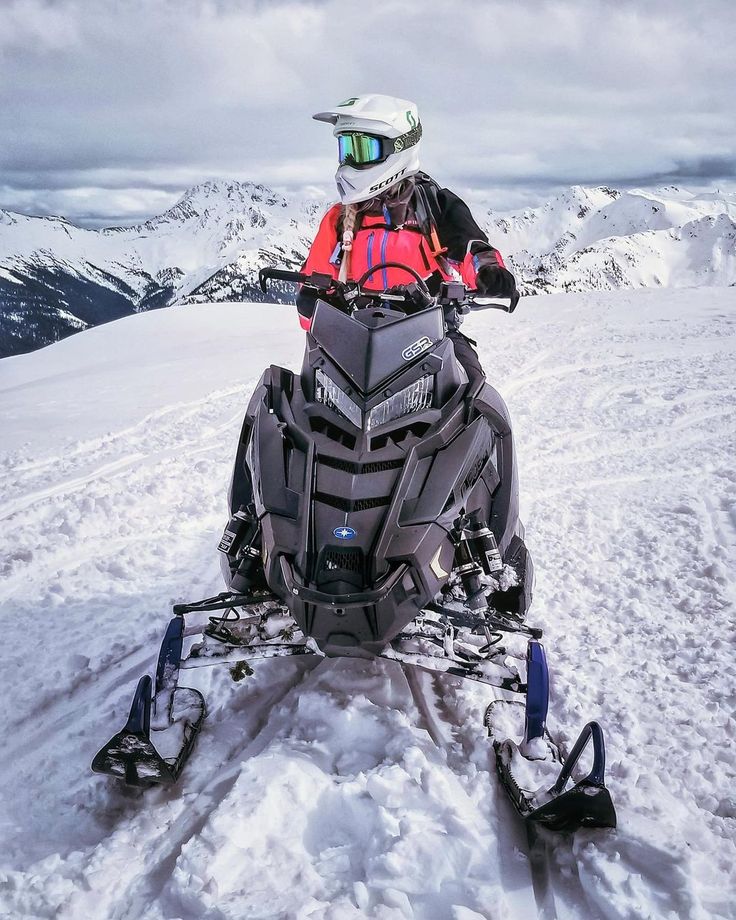 a man riding on the back of a snow mobile