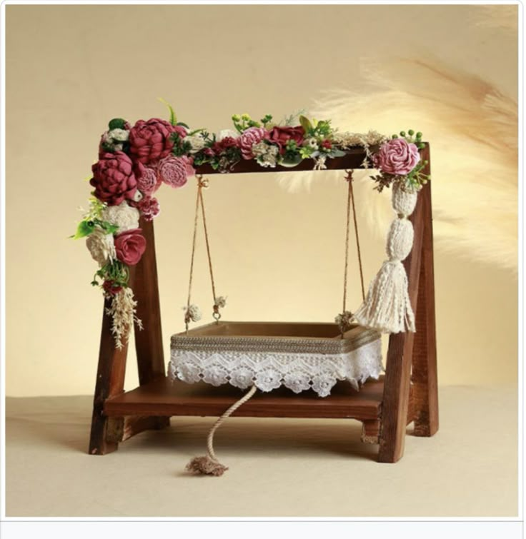 an old fashioned swing with flowers on it