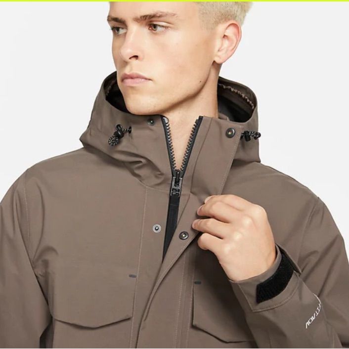 Standard Fit - Relaxed Feel Velcro Closure Cuffs Drawcords At The Hood Smooth Water Repellent Woven Fabric Military Style Design Two Way Zippered Closure Front Flop Pockets Slip In Hand Warmer Pockets Snap Closure Storm Flap Attached Corded Hood Color May Differ Due To Lighting Nike Functional Outdoor Outerwear, Nike Functional Outerwear For Hiking, Khaki Techwear Parka For Fall, Military Style Waterproof Parka For Fall, Winter Hiking Khaki Utility Jacket, Nike Outerwear With Detachable Hood For Outdoor, Nike Outdoor Outerwear With Detachable Hood, Combat Style Waterproof Fall Outerwear, Waterproof Combat Outerwear For Fall