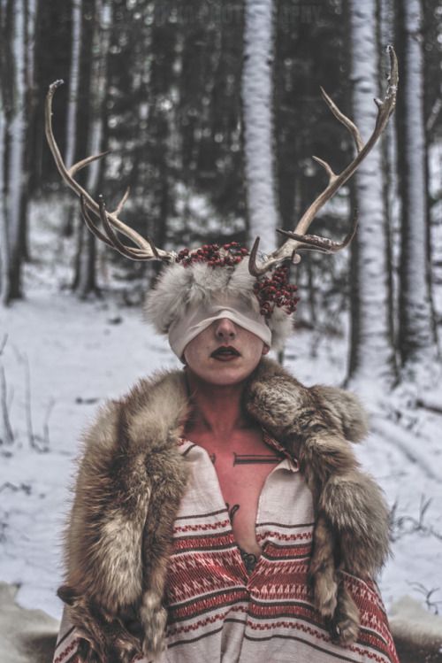 a woman with antlers on her head in the snow