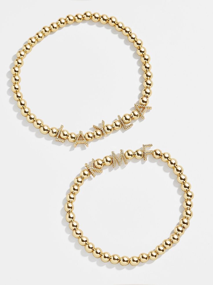 Add an extra special touch to your wrist stack with this classic design that's completely customizable. Our Custom Gold Twist Pisa Bracelet takes our beloved gold bead silhouette and adds twisted gold letter beads, each spaced apart by two beads in between. Add a name, phrase, or group of initials to create a piece you'll never take off. See our Letter Key for all options available. This bracelet features 5mm beads. Trendy Gold Charm Bracelet With Letter Beads, Trendy Gold Name Bracelet For Friendship, Trendy Gold Friendship Name Bracelet, Trendy Gold Friendship Bracelet, Gold Charm Bracelet With Letter Beads For Friendship, Gold Letter Beads Charm Bracelet For Friendship, Gold Metal Beaded Bracelets For Friendship, Trendy Gold Bracelet With Round Beads, Elegant Gold Charm Bracelet With Letter Beads