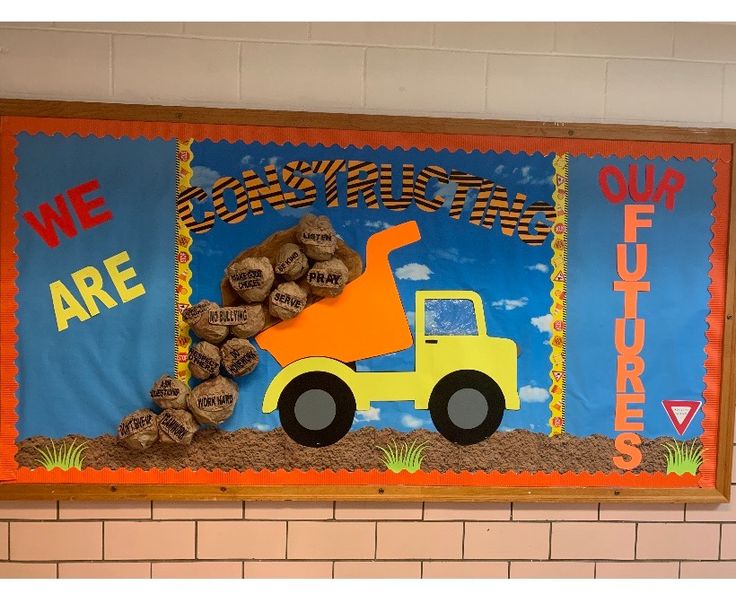 a bulletin board with a construction truck and wood logs on it that says we are here