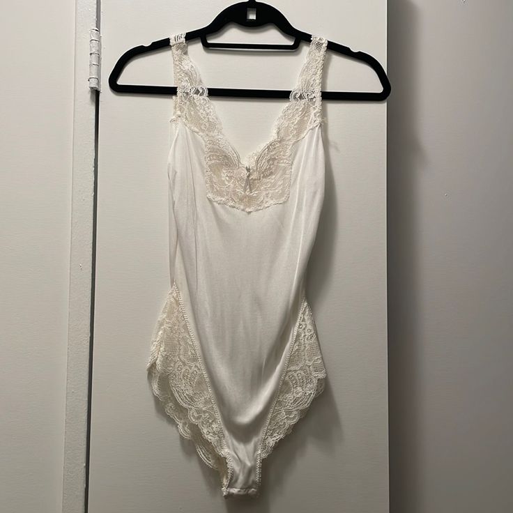 White And Cream Lace Never Worn Bodysuit Elegant Lined Bodysuit For Loungewear, Elegant White Sleeveless Bodysuit, Chic White V-neck Bodysuit, Elegant White One-piece Bodysuit, White Stretch Feminine Bodysuit, White Feminine Stretch Bodysuit, Sleeveless Summer Bodysuit With Lace Trim, Summer Sleeveless Bodysuit With Lace Trim, Sleeveless Lace Trim Bodysuit For Summer