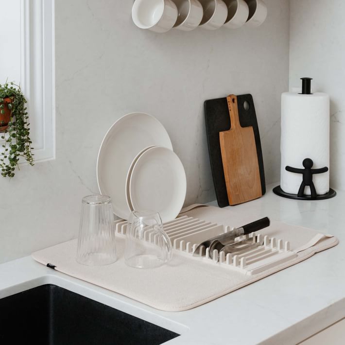 a kitchen counter with dishes and utensils on it, next to a sink