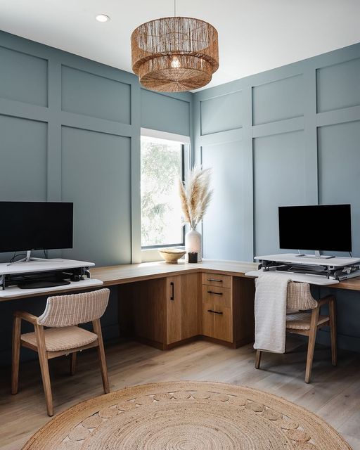 a home office with two computer screens on the desk