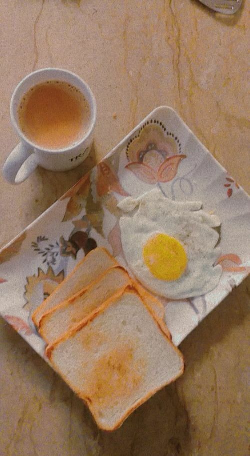 an egg and toast on a plate next to a cup of coffee