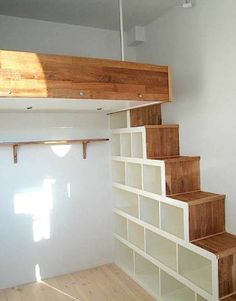 an empty room with white walls and wooden stairs