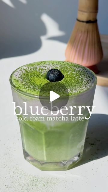 a green drink sitting on top of a white table