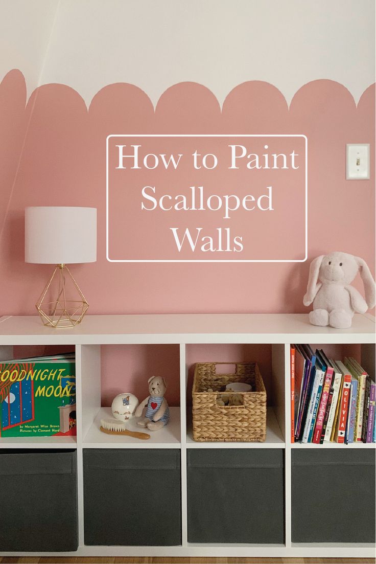 a pink wall with white scalloped walls and bookshelves