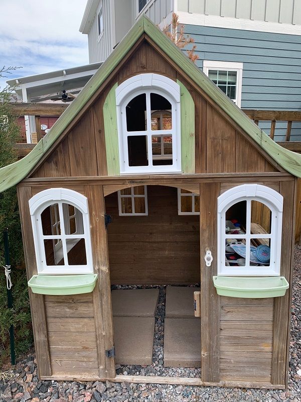 a small wooden house with windows and shutters on the front door is made out of wood