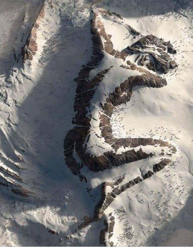 an aerial view of snow covered mountains and the word love spelled out in the middle