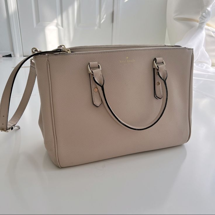 Beautiful Beige Kate Spade Bag Used As An Office Tote. Can Hold A Laptop, Books, Binders. Has Two Handles And And A Long Shoulder Strap. There Is A Small Light Pink Mark On The Front Of The Bag, Show In Pictures. Hardware On Bottom Of The Bag Has Light Wear As Show In Pictures. There Are Some Pen Marks On The Interior Of The Bag, Shown In Pictures. Otherwise This Bag Was Well Kept. Smoke Free Home. Cream Kate Spade Shoulder Bag For Daily Use, Kate Spade Cream Rectangular Bag, Kate Spade Cream Bag With Detachable Handle, Kate Spade Cream Bag With Gold-tone Hardware, Kate Spade Tote Bag With Gold-tone Hardware, Small Light, Kate Spade Bag, Binders, Light Pink