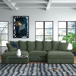 a living room scene with focus on the sectional sofa and large windowed area in the background