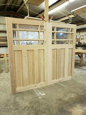 an unfinished building with wooden doors and windows