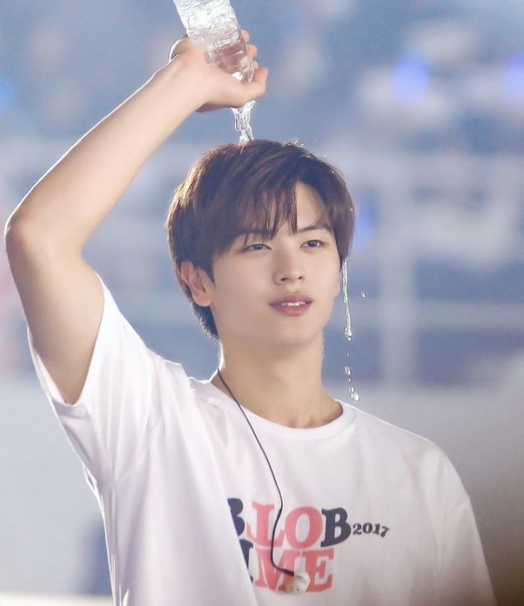 a young man holding up a water bottle