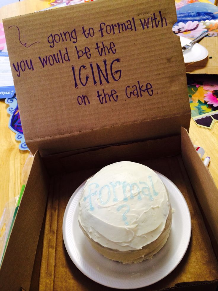 a cake in a box sitting on top of a table next to a sign that says going to formal with you would be the icing on the cake