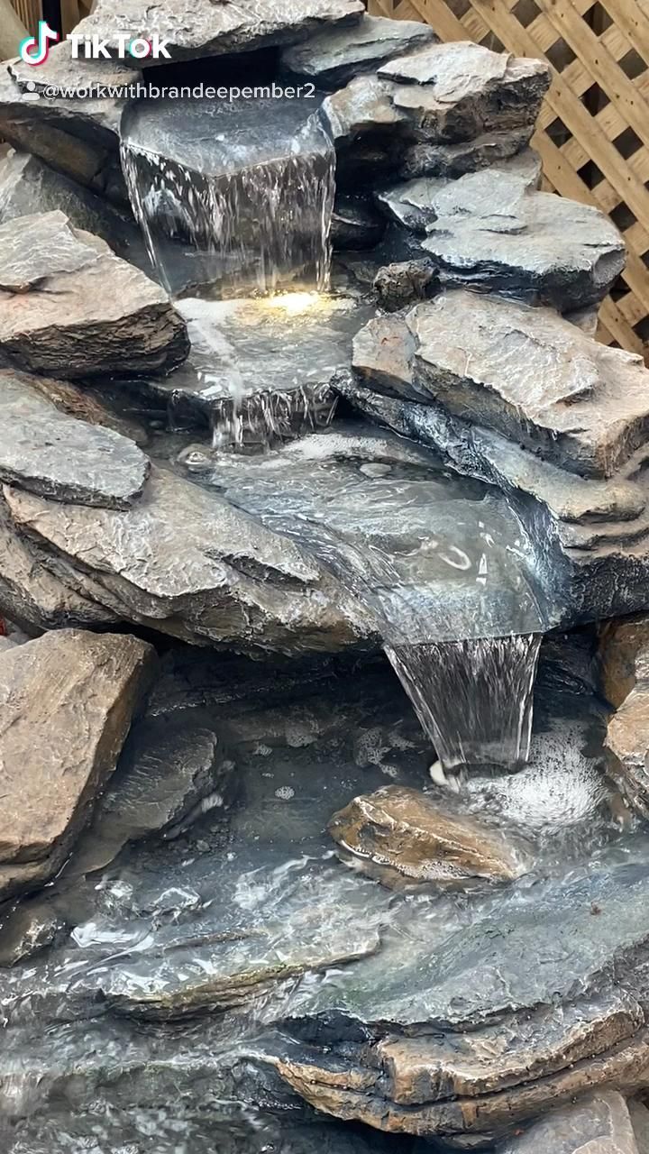 an outdoor waterfall with rocks and water