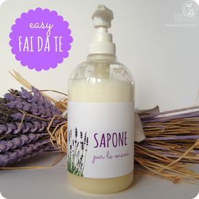 a bottle of soap sitting next to lavender flowers