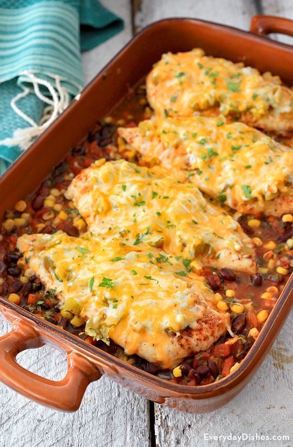 chicken enchilada casserole with beans and corn in an orange dish