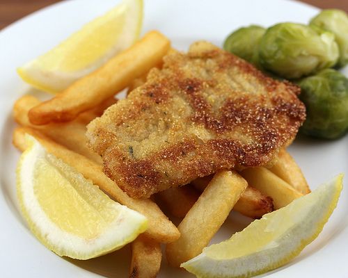 fried fish and fries on a plate with brussel sprouts