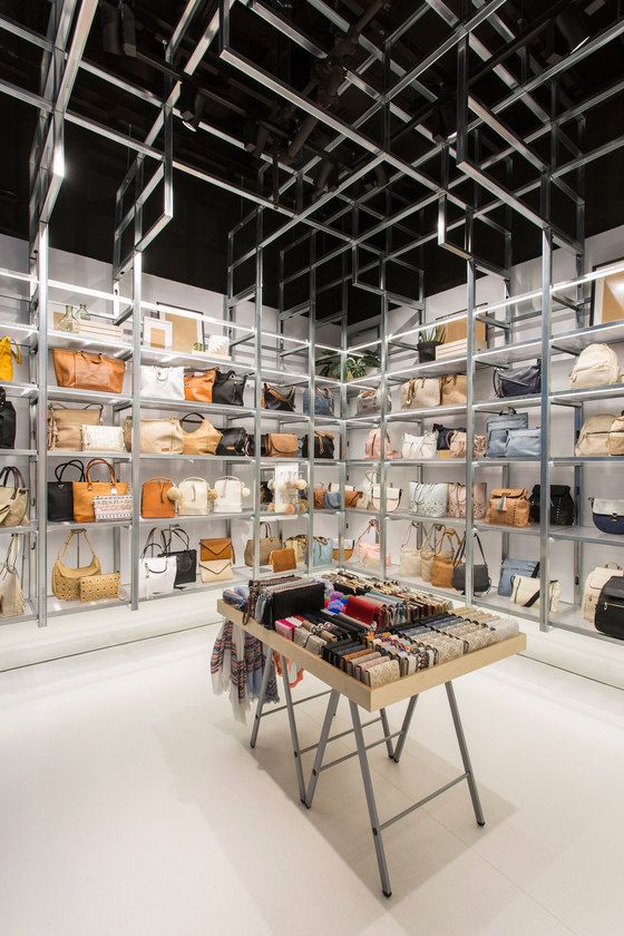 the shelves are filled with purses and handbags in this room, all lined up on metal shelving