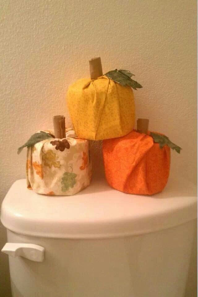 three toilet paper pumpkins sitting on top of a toilet