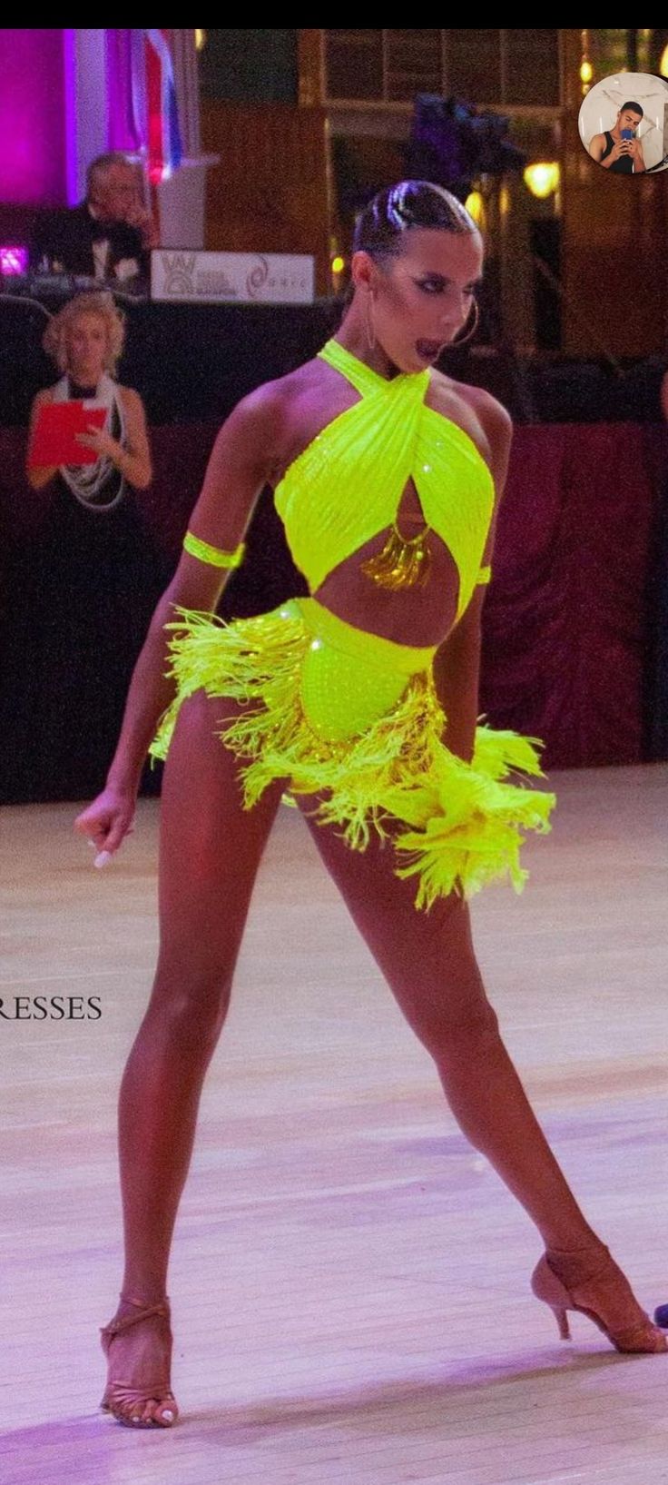 a woman in a neon yellow outfit is dancing