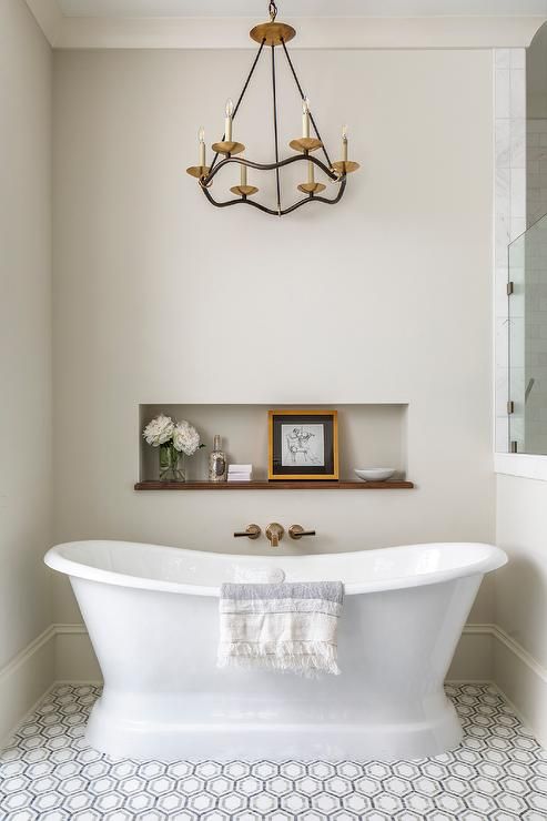 a white bath tub sitting under a chandelier