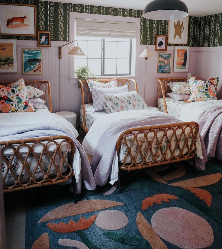 two twin beds in a room with pictures on the wall and rugs around them