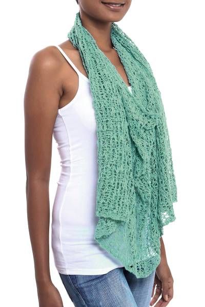 a woman wearing a green knitted scarf