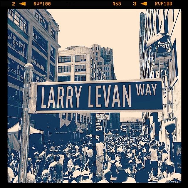 there is a large group of people walking down the street in this black and white photo