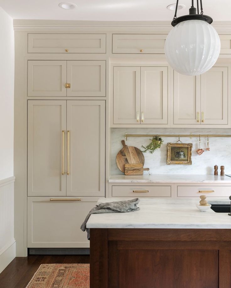 a large kitchen with white cabinets and marble counter tops, along with an area rug on the floor