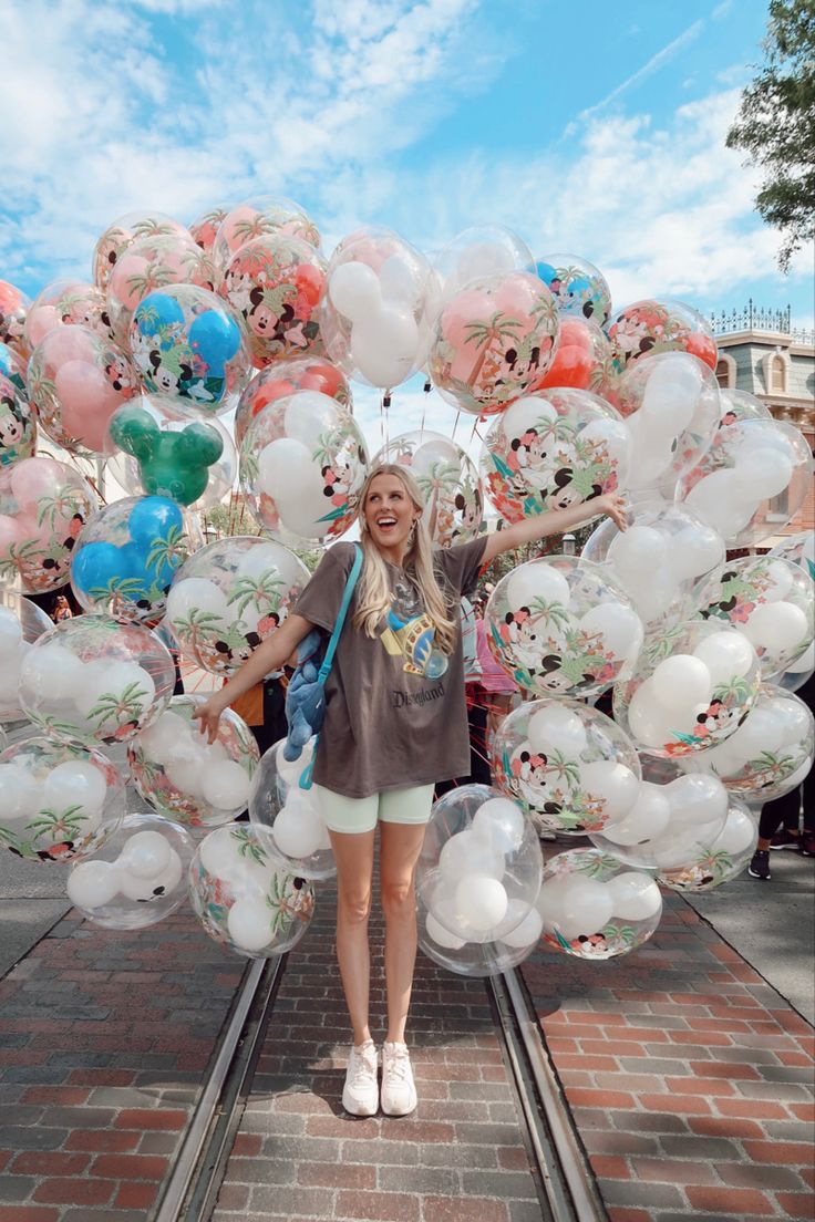 a woman standing in front of a bunch of balloons