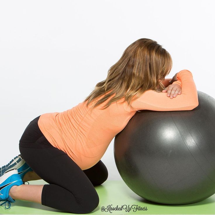 a woman sitting on an exercise ball with her back to the camera and looking down