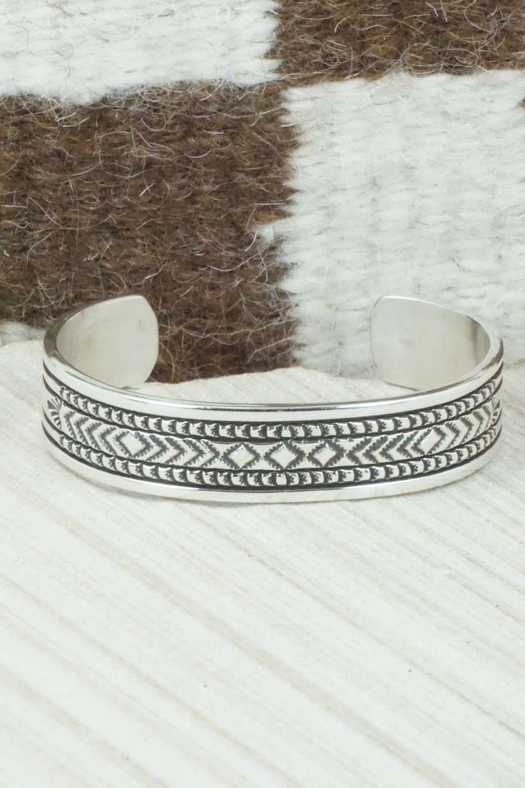 This sterling silver and bracelet was made by Navajo silversmith Bruce Morgan. The inside is signed B. Morgan and stamped sterling.Size: 5 1/4" (will fit up to a 6 3/8" wrist)Gap: 1 1/8"Width: 1/2"Free shipping on all orders! We ship with USPS and always include tracking. All orders ship within a day of payment.Returns are accepted up to 30 days after you receive your order. Just send us a message. Our shop offers cash back or store credit. The item must be returned in new condition. Artisan Sterling Silver Bracelet With Etched Details, Silver Southwestern Stamped Bracelets, Southwestern Silver Engraved Cuff Bracelet, Silver Stamped Southwestern Bracelets, Southwestern Engraved Silver Cuff Bracelet, Adjustable Silver Southwestern Bangle, Southwestern Stamped Silver Bracelets, Southwestern Style Engraved Silver Cuff Bracelet, Southwestern Style Etched Sterling Silver Bracelet