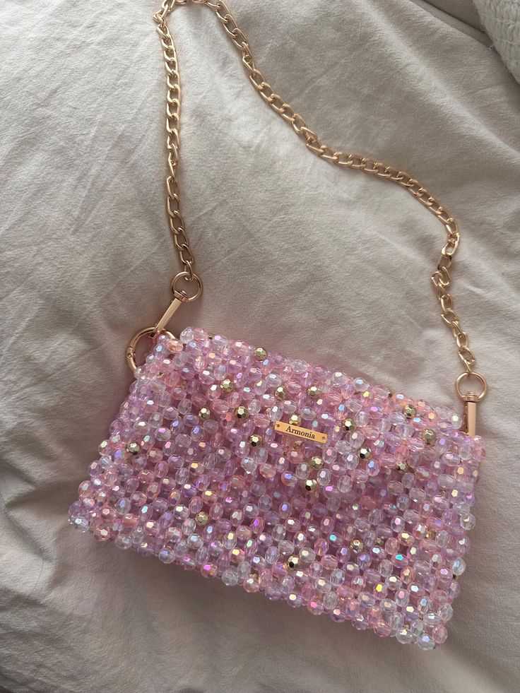 This elegant, handmade beaded handbag in delicate shades of pink, purple and white is a real eye-catcher. The shimmering beads and gold details give the bag a luxurious touch, while at the same time it is practical enough to hold all your essentials. Characteristics - High-quality handmade beadwork - Colors: pink, purple, white with glittery accents and gold details - Secure magnetic closure - Offers space for the most important items such as cell phone, keys and lipstick Care instructions - Wip Hand Beaded Bag, Beaded Bag, Beaded Handbag, Beaded Purses, Purple And White, Beaded Bags, Shopping Spree, Hand Beading, Gold Details