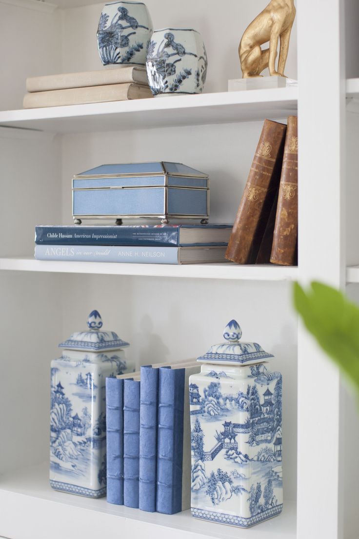 blue and white bookshelves with vases on them