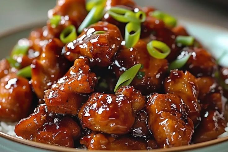 a close up of a plate of food with meat and sauce on it's surface