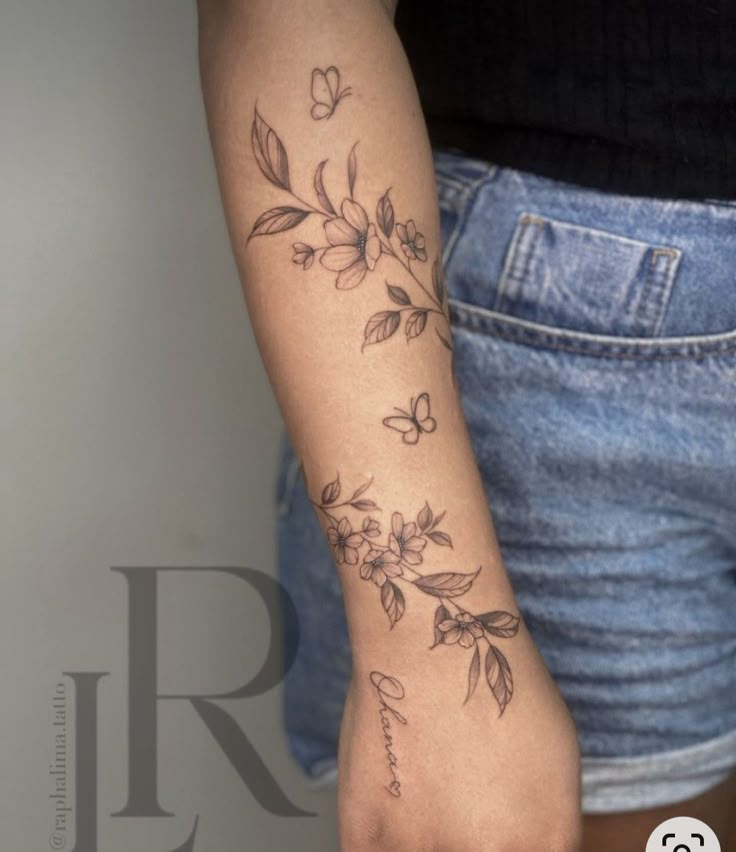 a woman's arm with flowers on it, and the word love written in cursive writing