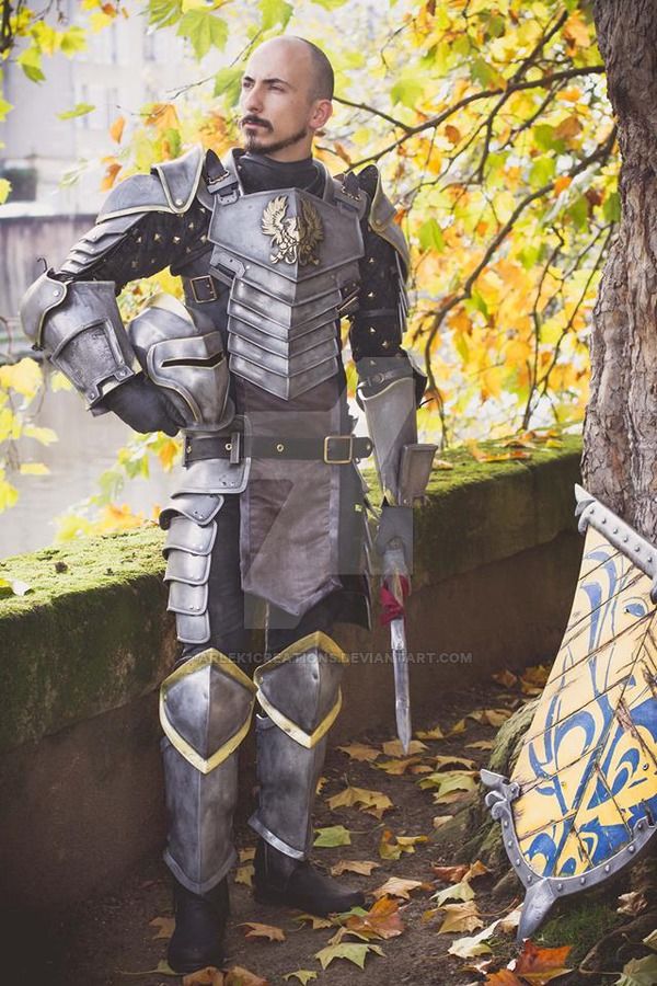 a man in armor standing next to a tree