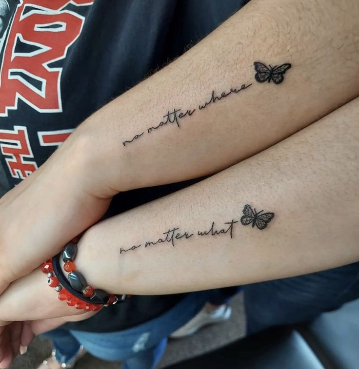 two people with matching tattoos on their arms, one has a butterfly and the other has a quote