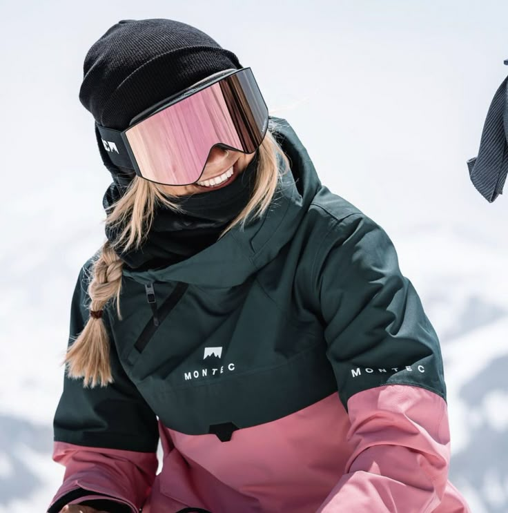 a woman with skis and goggles on sitting in the snow