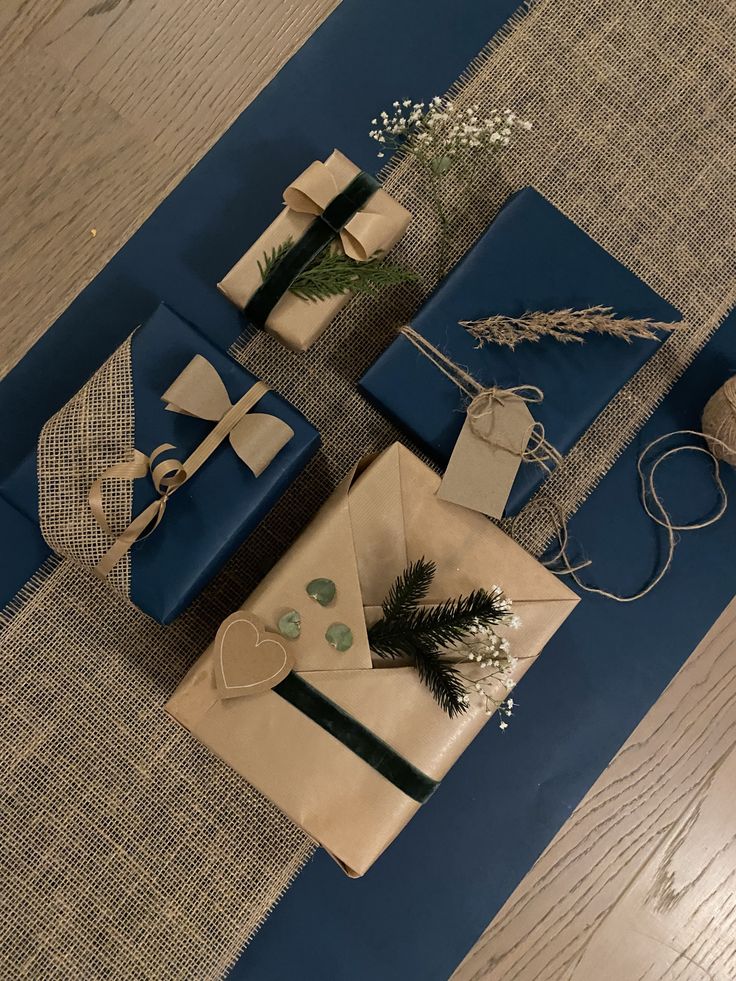 presents are wrapped in blue paper and tied with twine, on top of the table