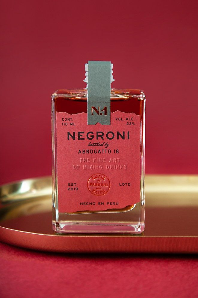 a bottle of perfume sitting on top of a gold tray next to a red wall