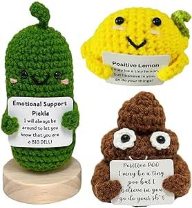 three crocheted stuffed animals holding signs