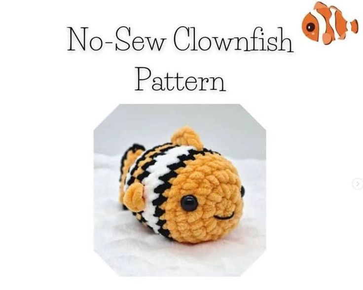 a crocheted stuffed animal with an orange and black striped fish on it's face