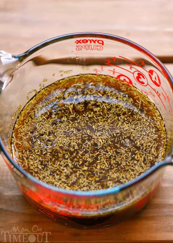 a measuring cup filled with spices on top of a wooden table