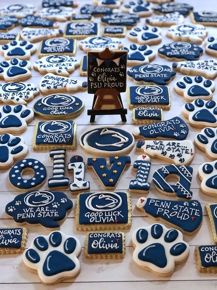 cookies decorated with blue and white icing are arranged on a table