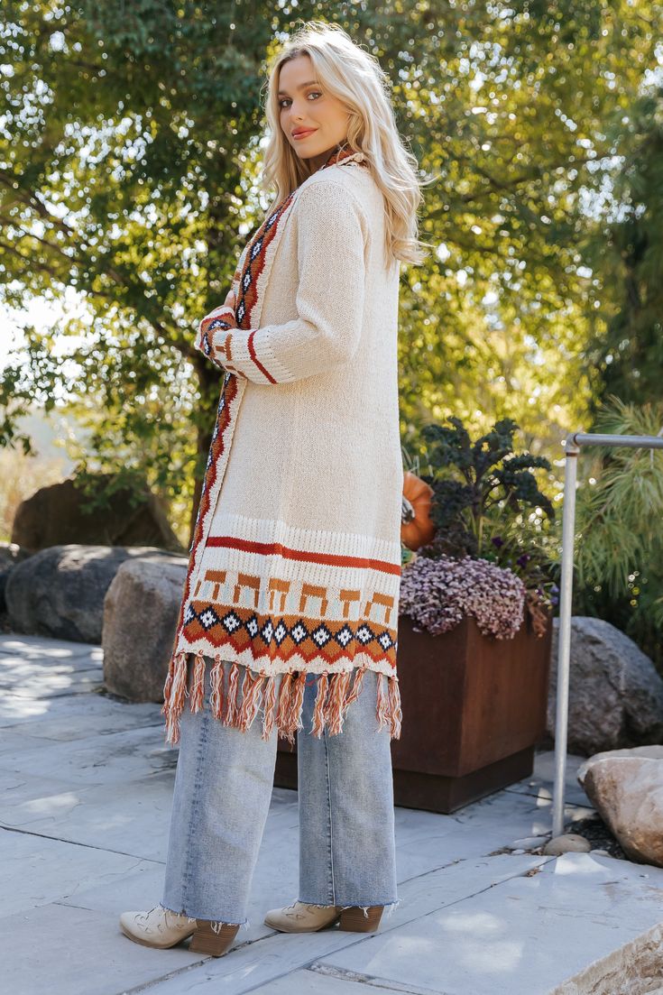 Our Beige Tribal Print Fringe Duster Cardigan is perfect for any fall occasion! This duster-length cardigan showcases a bold tribal print and a fringe hem for added style. It offers both comfort and a touch of bohemian flair, making it perfect for layering throughout the season. Layer it over a basic top and pair with jeans, ankle booties, and matching accessories to complete the look. Beige Bohemian Cardigan For Fall, Bohemian Beige Cardigan For Fall, Bohemian Fall Outerwear With Tassels, Long Fall Outerwear With Tassels, Bohemian Fair Isle Pattern Cardigan For Fall, Bohemian Fringe Outerwear For Fall, Bohemian Beige Outerwear With Tassels, Bohemian Cardigan For Fall Layering, Bohemian Fall Cardigan With Tassels