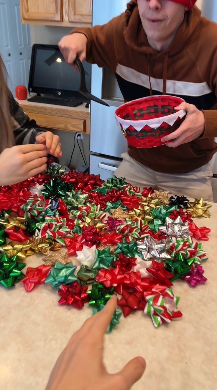 two children are making christmas decorations on the kitchen counter top, one boy is holding a bowl with candy canes in it